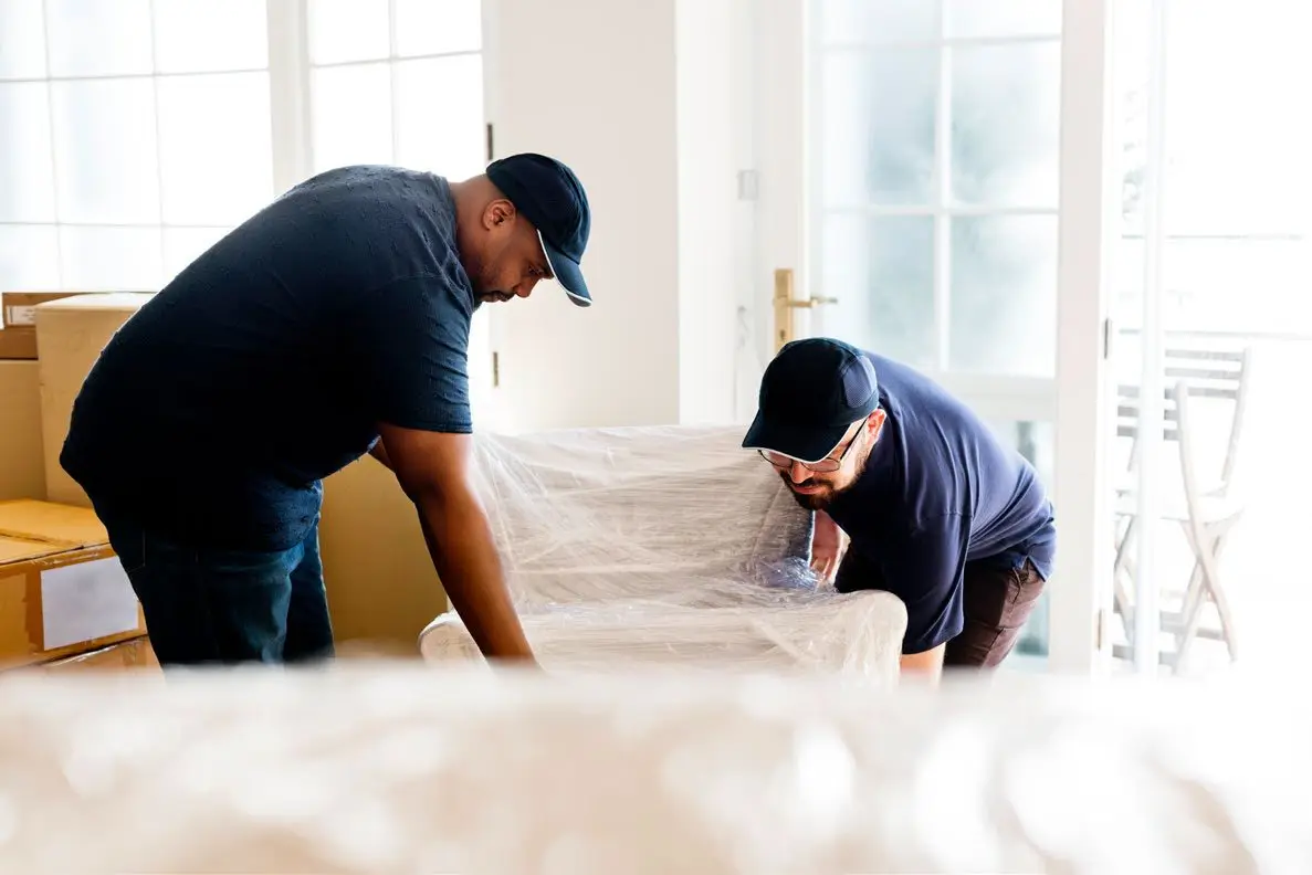 Movers respectfully wrapping and clearing furniture from a home
